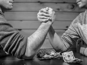 two guys armwrestling and some money laying on the table