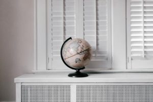 A window with with a world globe standing on the window shield
