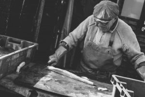 Black and white photo of man doing woodwork